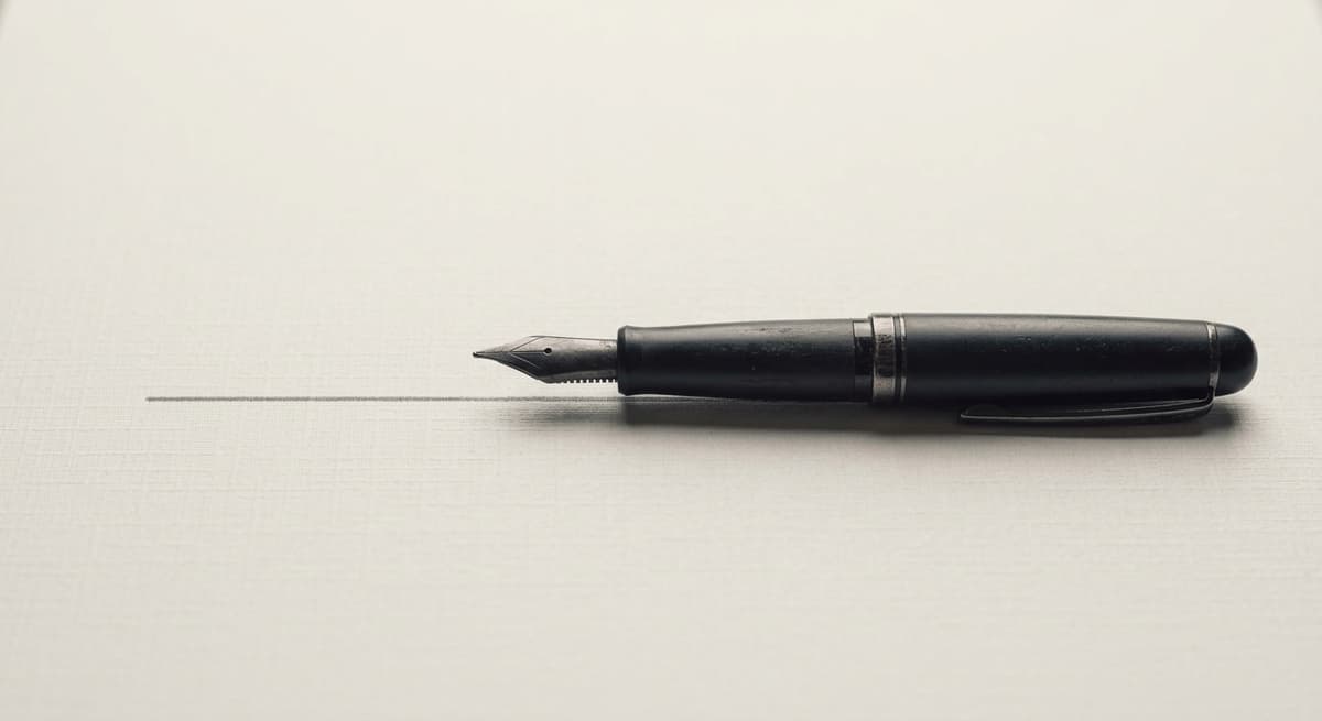 a fountain pen resting on the signature line of a printed document