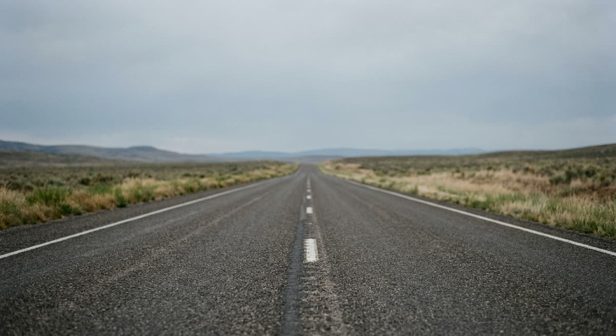 an empty highway stretching toward the horizon under a clear sky