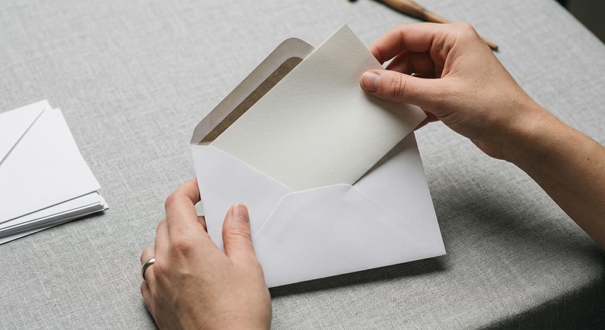United States hands placing a document into a white envelope